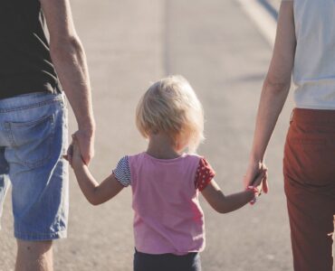 Free parent holding child's hand