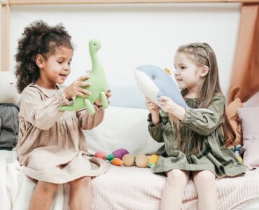 photo of two girls playing with stuffed animals